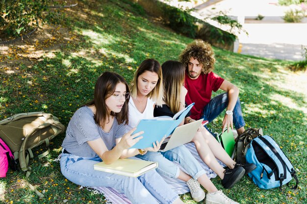Mujeres estudiando cerca de amigos que hablan