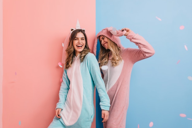 Mujeres fascinantes en kigurumi relajándose juntas