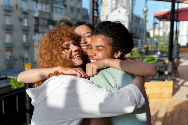 Mujeres felices abrazando tiro medio