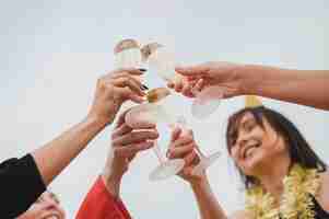 Foto gratuita mujeres felices animando copas de champán en la fiesta en la azotea