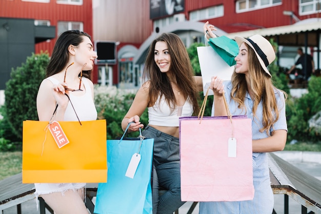 Las mujeres felices charlando después de ir de compras