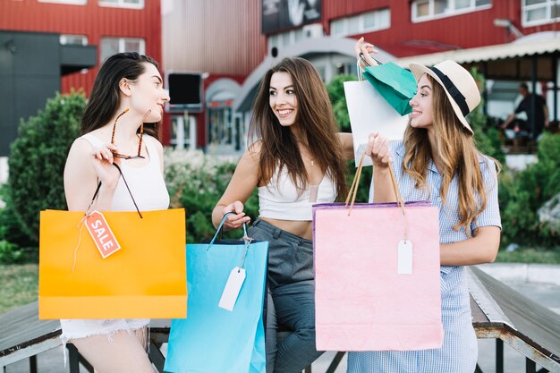 Las mujeres felices charlando después de ir de compras