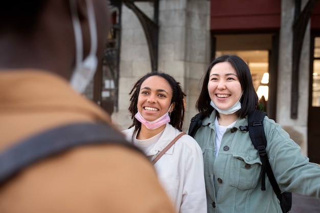 Mujeres felices conociendo a un amigo al aire libre