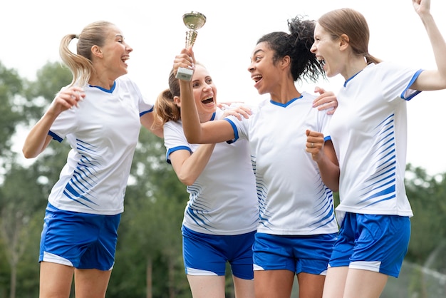 Foto gratuita mujeres felices con copa de oro