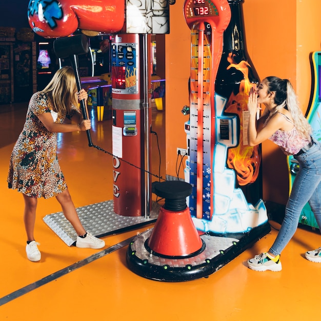 Foto gratuita mujeres felices jugando juego de arcade