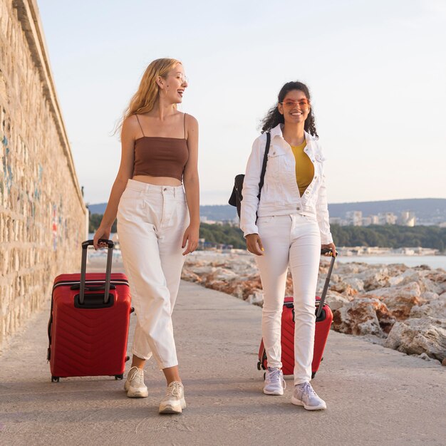 Mujeres felices de tiro completo con equipaje