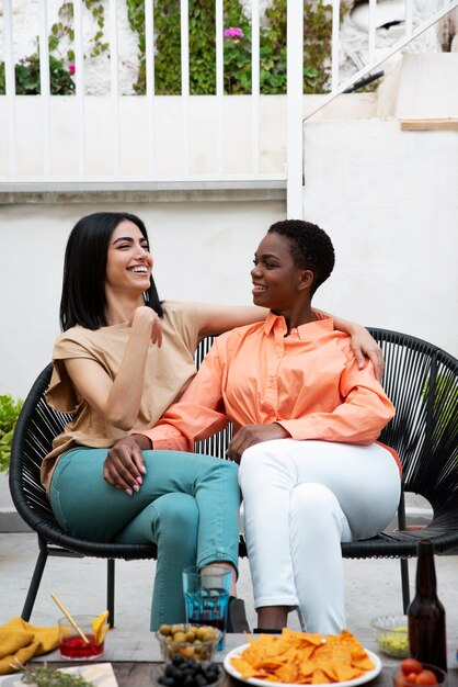 Mujeres felices de tiro completo sentadas juntas