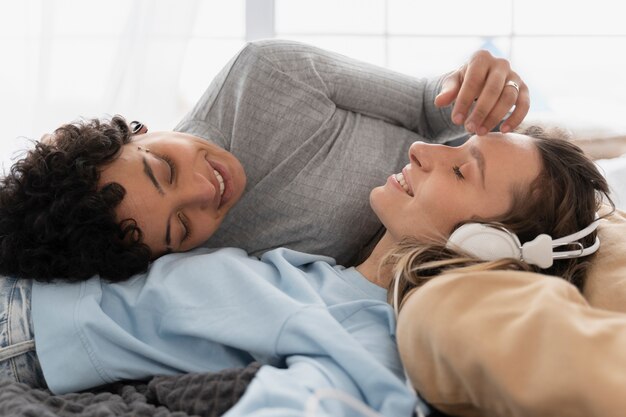 Mujeres felices de tiro medio acostadas juntas