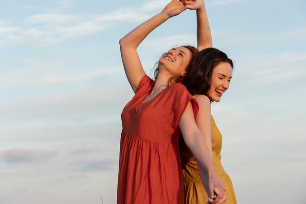 Mujeres felices de tiro medio bailando al aire libre
