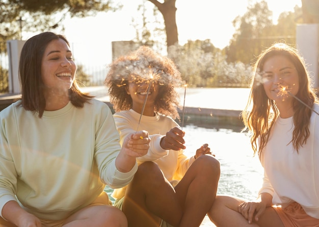 Mujeres felices con tiro medio de fuegos artificiales