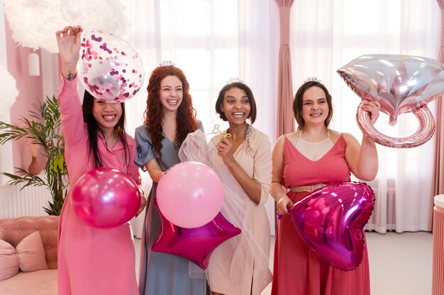 Mujeres felices de tiro medio con globos.