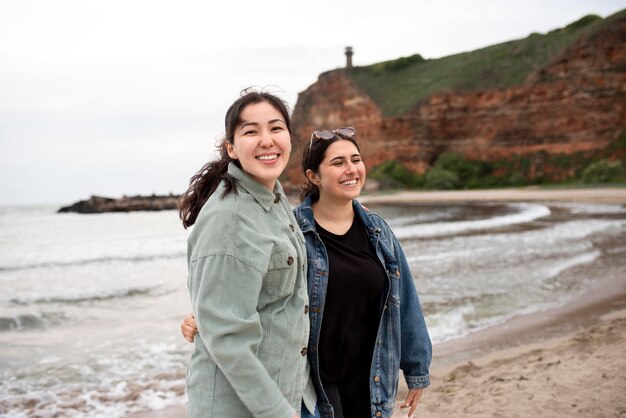 Mujeres felices en tiro medio junto al mar