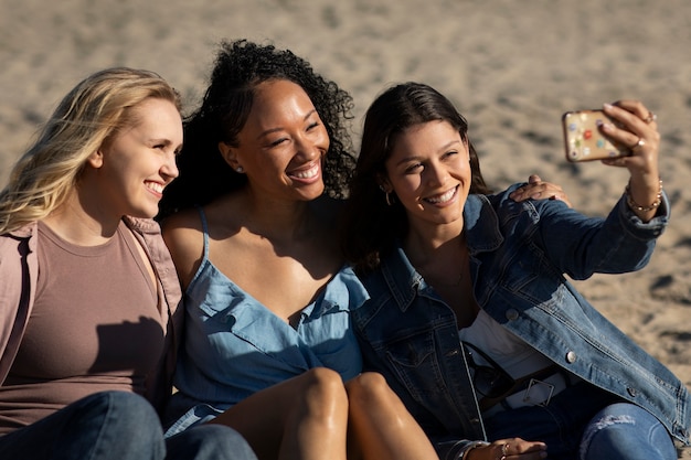 Foto gratuita mujeres felices de tiro medio tomando selfie