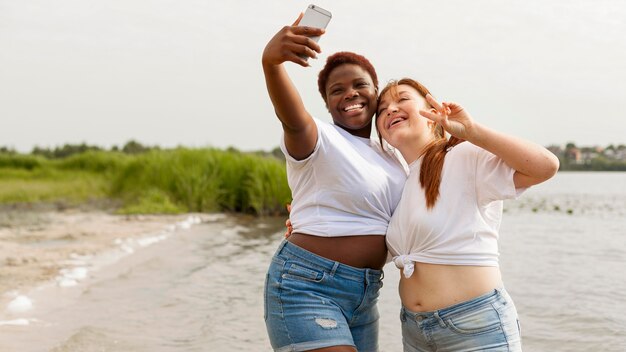 Mujeres felices tomando selfie en la playa