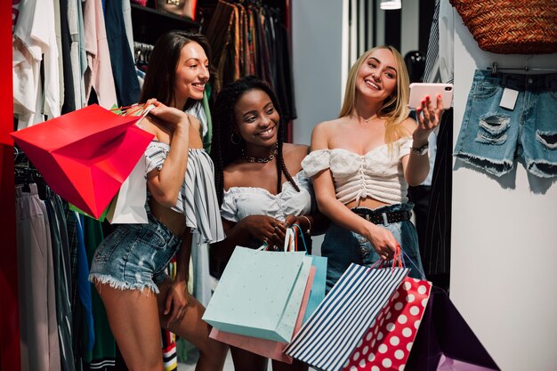 Mujeres felices tomando selfie en tienda