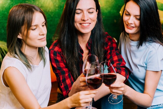Mujeres felices tostado vino en fiesta