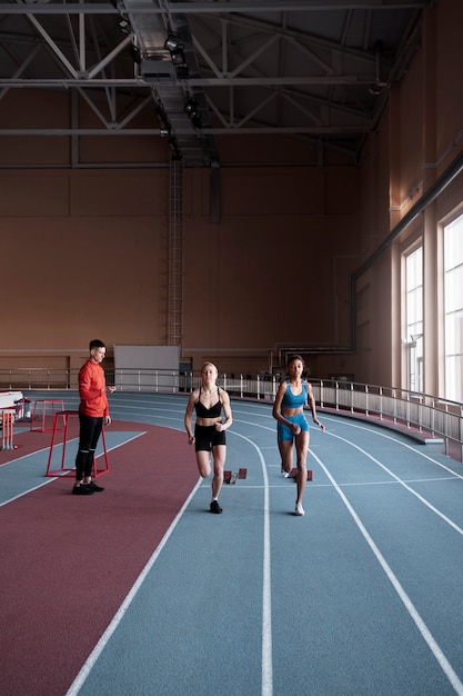 Foto gratuita mujeres en forma de tiro completo corriendo en el gimnasio