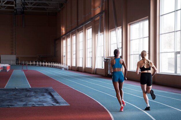 Mujeres en forma de tiro completo corriendo juntas