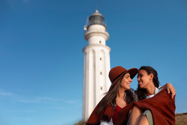 Mujeres de frente posando con un faro