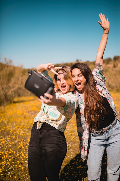 Mujeres gesticulando y tomando selfie