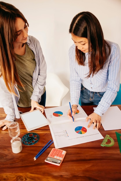 Foto gratuita mujeres con gráficos haciendo investigación