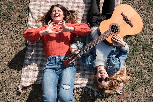 Foto gratuita mujeres con guitarra en coverlet.