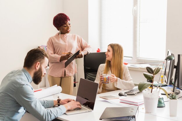 Mujeres hablando cerca de colega de trabajo