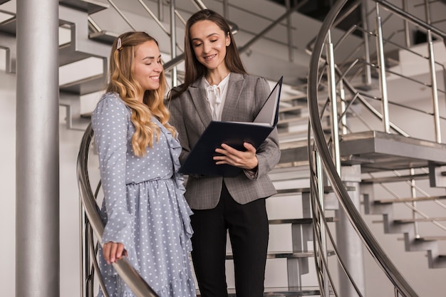 Foto gratuita mujeres hablando de negocios en una escalera