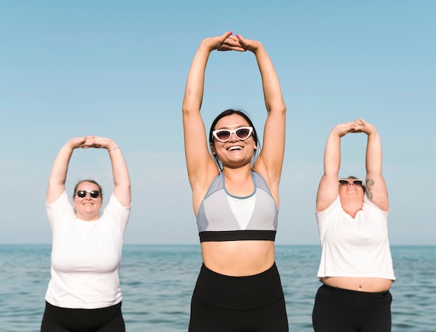 Foto gratuita mujeres haciendo deporte junto al mar