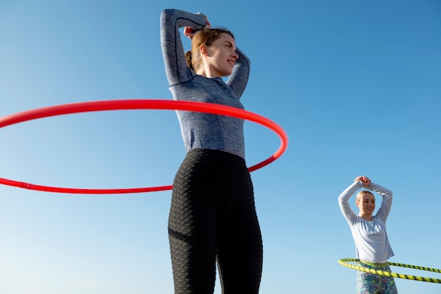 Mujeres haciendo ejercicio con círculo de hula hoop