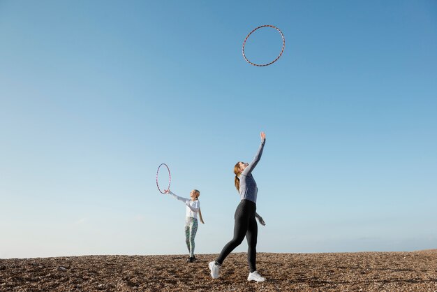 Mujeres haciendo ejercicio con círculo de hula hoop