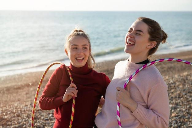 Foto gratuita mujeres haciendo ejercicio con círculo de hula hoop