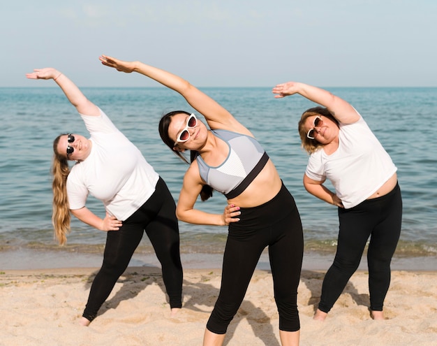 Mujeres haciendo ejercicios al lado del mar.