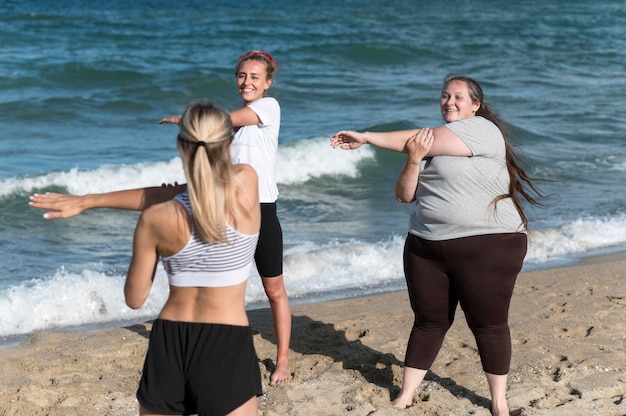 Mujeres haciendo ejercicios en la playa de tiro medio