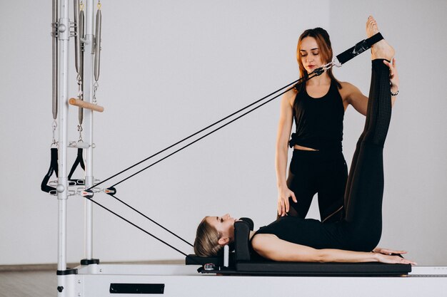 Mujeres haciendo pilates en un reformador.