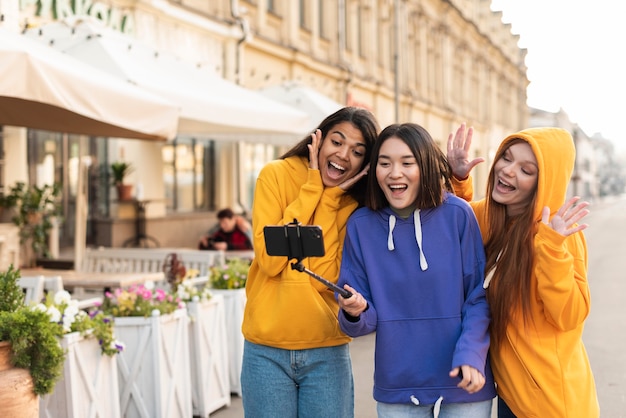 Foto gratuita mujeres haciendo un selfie con un palo de selfie