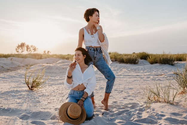 Mujeres hermosas con estilo en las vacaciones de verano en la playa, estilo bohemio, divirtiéndose