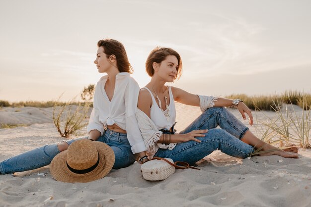 Mujeres hermosas con estilo en las vacaciones de verano en la playa, estilo bohemio, divirtiéndose