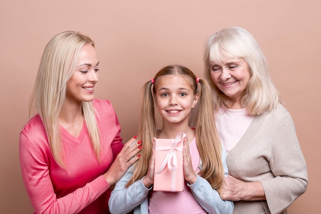 Mujeres hermosas felices que sostienen una caja de regalo