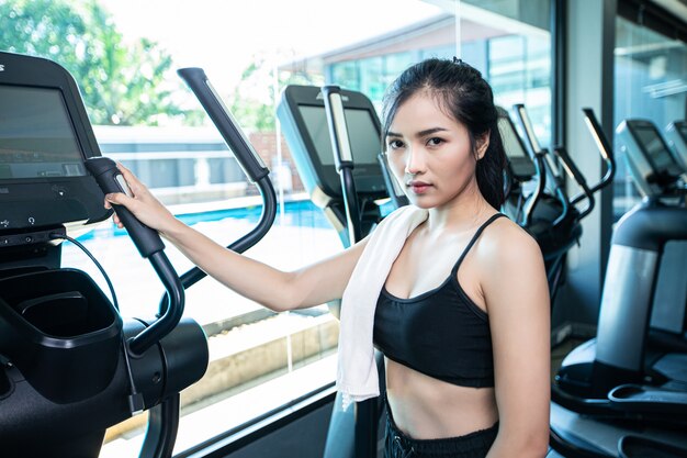 Mujeres hermosas fitness preparan para correr en la cinta en el gimnasio.