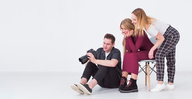 Foto gratuita mujeres y hombre mirando fotos en estudio y espacio de copia