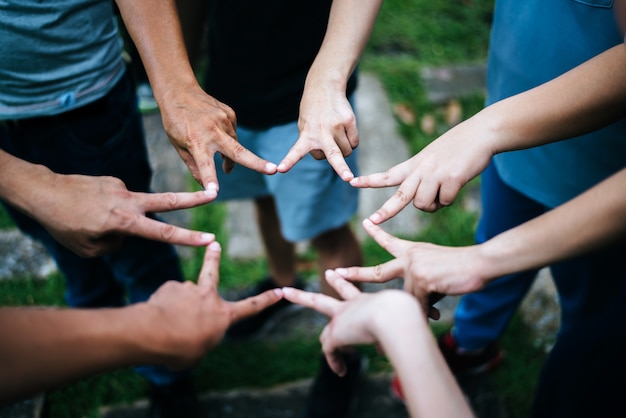 Mujeres y hombres amigos hacen forma de estrella con los dedos. El éxito, el concepto de amistad.