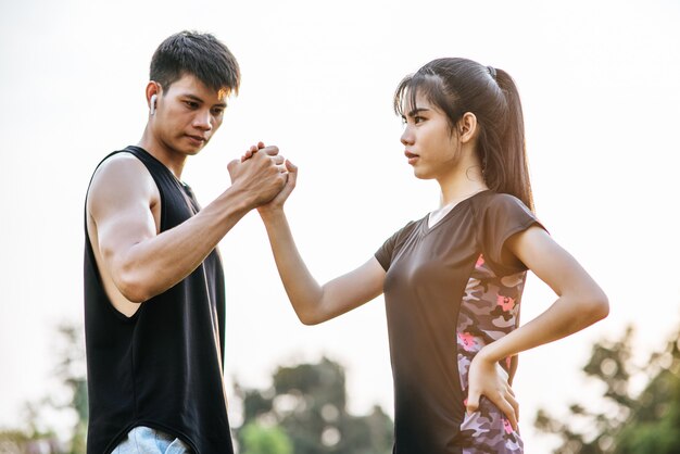 Las mujeres y los hombres están tomados de la mano para hacer ejercicio.