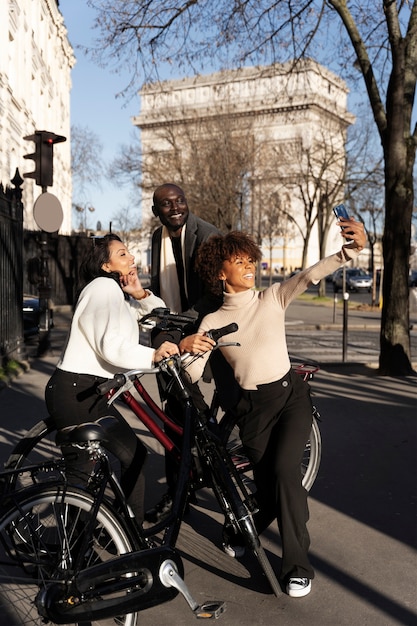 Mujeres y hombres tomando selfie andando en bicicleta en la ciudad de francia