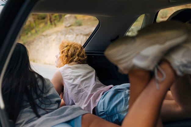 Foto gratuita mujeres jóvenes, acostado, en coche