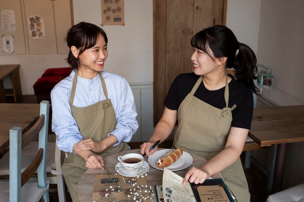 Foto gratuita mujeres jóvenes arreglando su pastelería