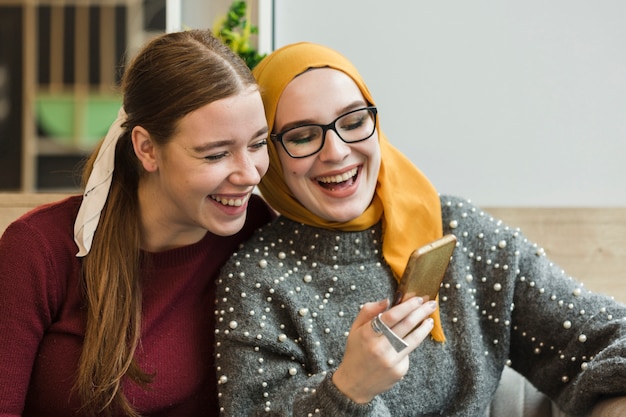 Mujeres jovenes atractivas que ríen juntas