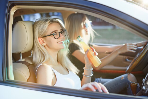 Las mujeres jóvenes en el auto sonriendo