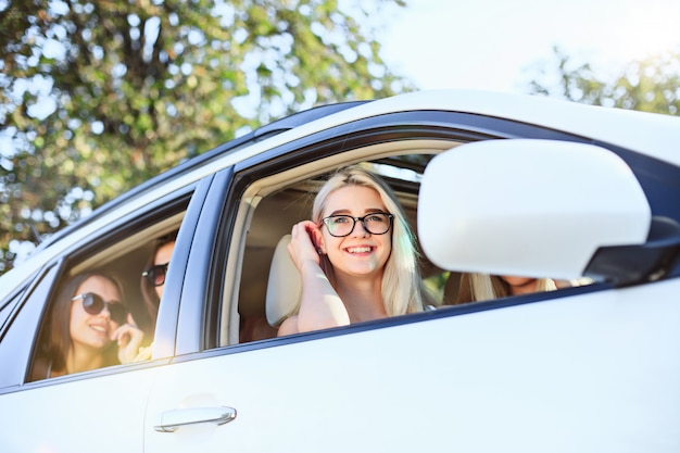 Las mujeres jóvenes en el auto sonriendo