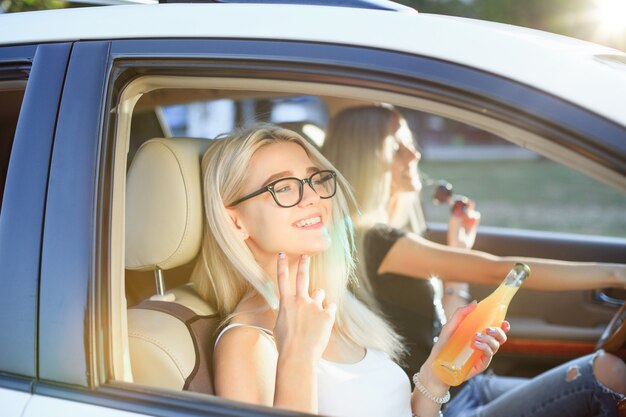 Las mujeres jóvenes en el auto sonriendo